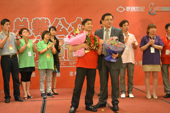 俞總懷抱（bào）證書和鮮花，與吳老師合影